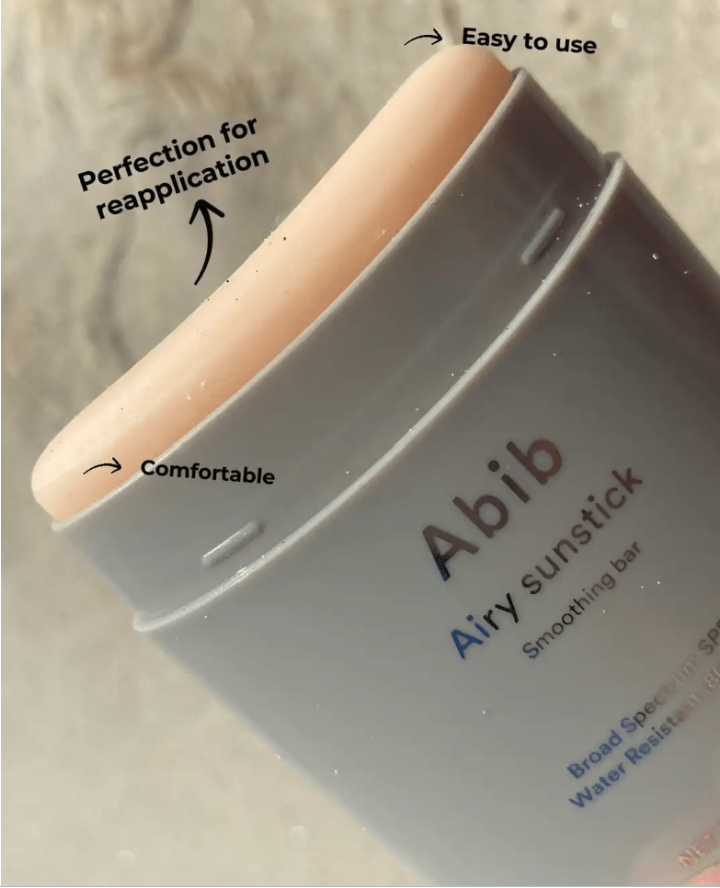 a close up of a person holding a tube of airy sunscreen