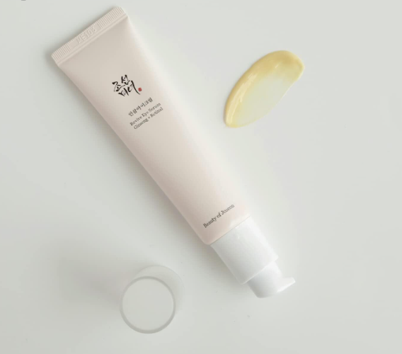 a tube of cream sitting next to a half of a lemon