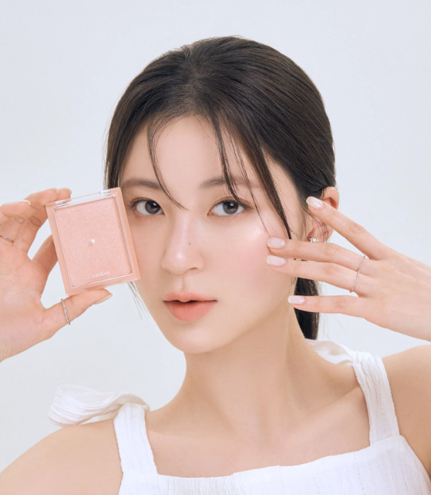 A model holding the rom&nd See-Through Veil Lighter, showcasing her flawless glow and radiant skin.