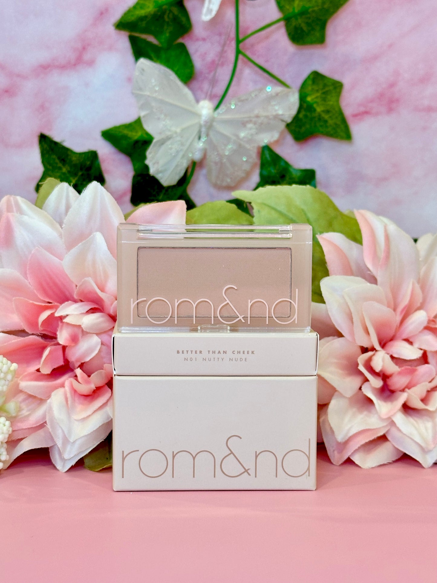 Rom&nd Better Than Cheek blush in N01 Nutty Nude, elegantly presented with floral accents, perfect for adding a subtle touch of color to your makeup routine.