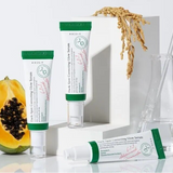 a couple of tubes of toothpaste sitting next to a piece of fruit