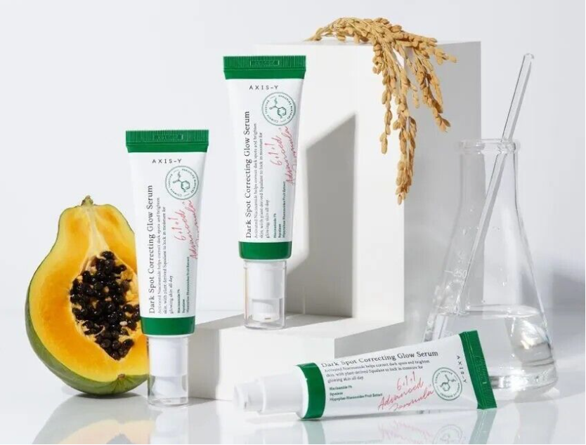 a couple of tubes of toothpaste sitting next to a piece of fruit