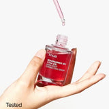 a person holding a bottle of liquid in their hand