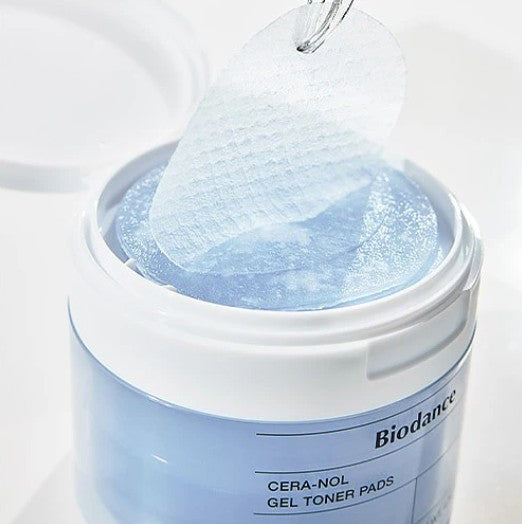 Close-up of Biodance Cera-Nol Gel Toner Pads being pulled from the tub, highlighting the gel texture and innovative packaging.
