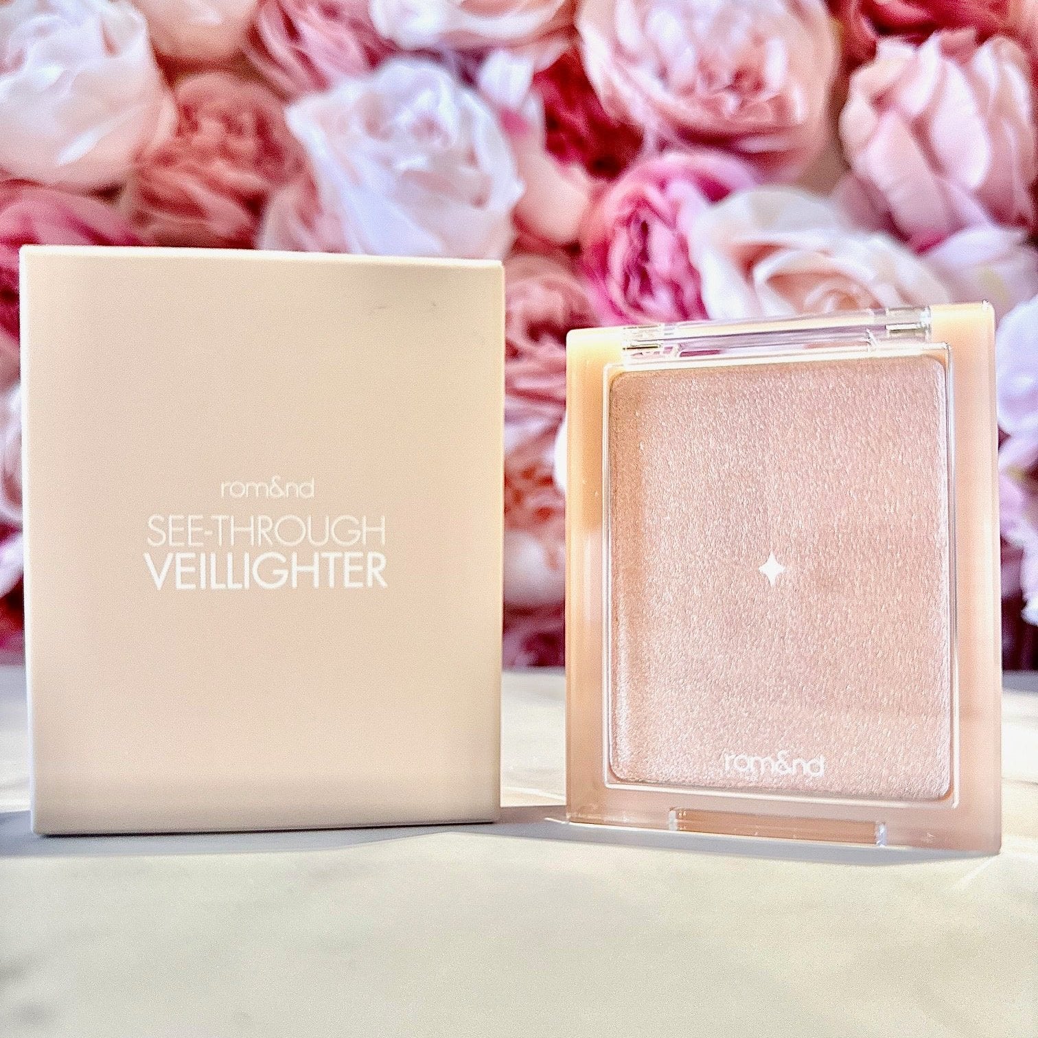 rom&nd See-Through Veil Lighter packaged beautifully, highlighting the shimmering highlighter's name with elegant floral background.