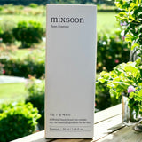 A captivating outdoor shot of the Mixsoon Bean Essence packaging nestled among greenery, reflecting the brand's clean beauty ethos and commitment to essential skincare.