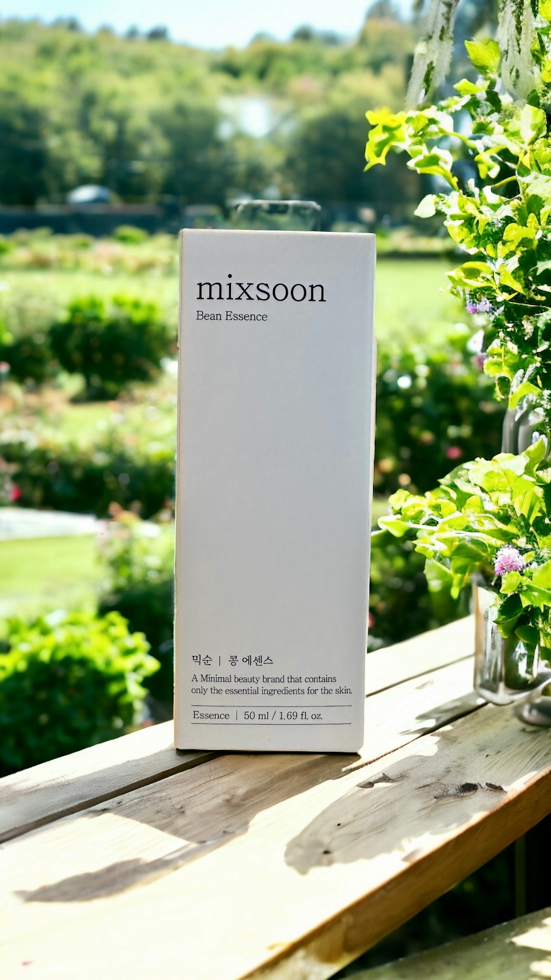A captivating outdoor shot of the Mixsoon Bean Essence packaging nestled among greenery, reflecting the brand's clean beauty ethos and commitment to essential skincare.