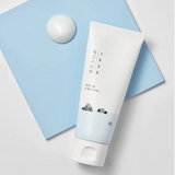 Round Lab 1025 Dokdo Sleeping Pack 100ml displayed against a soft blue backdrop, emphasizing its soothing and hydrating properties.