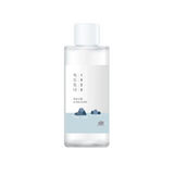 Round Lab 1025 Dokdo Toner bottle featuring a minimalistic design with blue tones and mountain imagery, embodying a hydrating exfoliator with deep sea water.