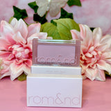 A charming display of rom&nd Better Than Cheek blush in N02 Vine Nude with blooming floral arrangements, merging elegance and beauty for a delightful blush experience.