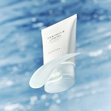 The Skin1004 Madagascar Centella Hyalu-Cica Water-Fit Sun Serum against a blue ocean backdrop, emphasizing its refreshing, hydrating properties ideal for sensitive skin.