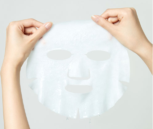 Hands holding a translucent sheet mask representing the Torriden Dive-In Low Molecule Hyaluronic Acid Mask, ideal for showcasing skin rejuvenation and hydration.