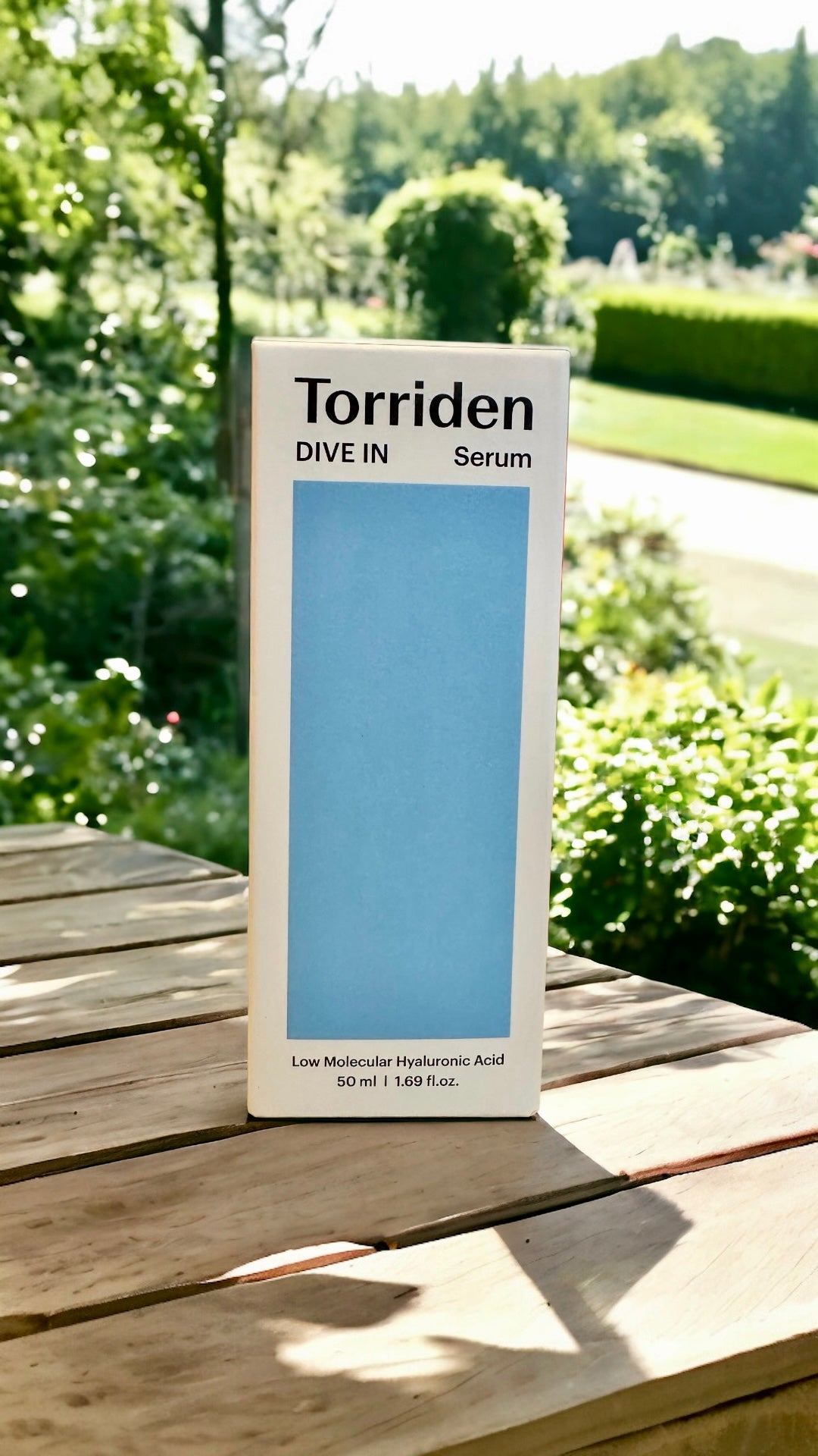 Torriden Dive In Serum box set against a natural outdoor backdrop, emphasizing the clean beauty aspect of the product.