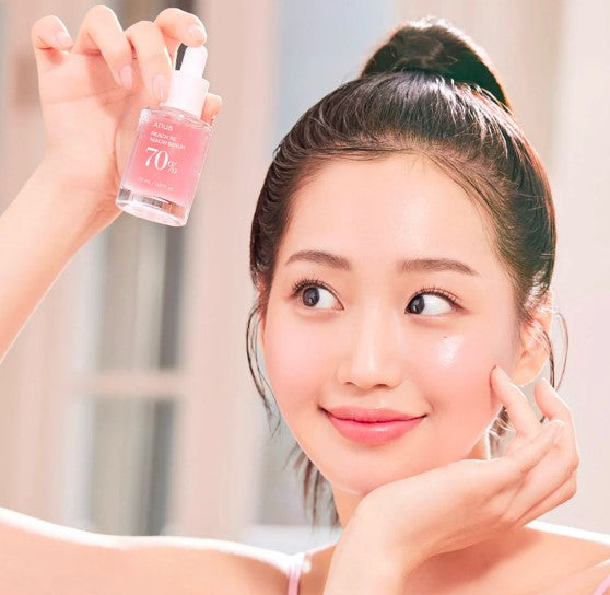 a woman holding up a bottle of pink nail polish