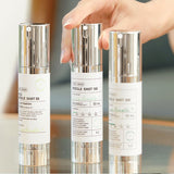 A hand holding VT Cosmetics Mild Reedle Shot 50, Reedle Shot 100, and another essence, showcasing the product range for comprehensive skin care.