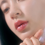 Glistening lips featuring rom&nd Glasting Water Gloss in Sanho Crush shade, emphasizing the pink and gold speckled gloss.